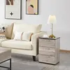 A living room scene with a sofa, a side table with a lamp and a cup, and artwork on the wall. Produktbild-Vorschau
