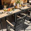 An outdoor dining set with a table and chairs on a patio. Produktbild-Vorschau