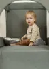 A baby sitting inside a travel crib. Anteprima dell’immagine prodotto