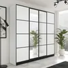 A modern wardrobe with mirrored doors in a bright, airy room with plants and a window view. Voir les images du produit