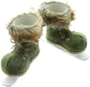 A pair of decorative green boots with faux fur trim, mounted on white skis, presented against a white background. Produktbild-Vorschau