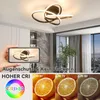 A hand holding a smartphone showing a ceiling lamp, with a comparison of light quality on oranges below. Produktbild-Vorschau
