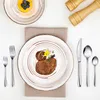 A table setting with plates, cutlery, and food. Produktbild-Vorschau
