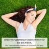 A woman lying on grass with her eyes closed and smiling. Produktbild-Vorschau