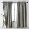 Two gray curtains hanging on a black rod in front of a window. Produktbild-Vorschau