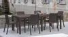 A brown rectangular outdoor dining table with chairs set up on a stone patio next to a building with a water wheel. Produktbild-Vorschau