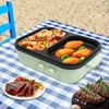 A multi-functional electric pot and grill set up on a picnic blanket on a beach, with food being cooked and served. Produktbild-Vorschau