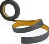 A roll of self-adhesive skirting board tape is unspooling onto a white surface. Produktbild-Vorschau