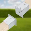 Two metal post anchors attached to wooden posts, set against a blurred background of green grass and blue sky. Anteprima dell’immagine prodotto
