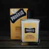 A bottle of Proraso Wood and Spice After Shave Balm is displayed next to its packaging on a wooden surface. Podgląd zdjęcia produktu
