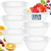 A stack of white bowls with fruit and ice cream in the background. Voir les images du produit