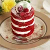 A close-up of a red velvet dessert with cream and cherries on a plate with a spoon. Produktbild-Vorschau