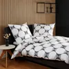 A bed with bedding set featuring a geometric pattern, set against a slatted wooden wall. Produktbild-Vorschau