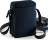 A navy blue cross-body bag is shown against a white background. A black wallet and part of a tablet are visible behind the bag. Anteprima dell’immagine prodotto