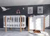A nursery room with a crib, dresser, and decorations. Produktbild-Vorschau
