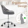 A dark gray velvet office chair is shown from the side, with an inset graphic illustrating ergonomic support for the spine. The background is a blurred interior scene with shelves and a guitar. Produktbild-Vorschau