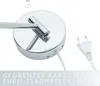 Close-up of a chrome-finished lamp base with a white cable and plug, with text overlay. Produktbild-Vorschau