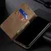 A close-up view of a brown leather wallet-style phone case with a phone inside, showing credit cards and a banknote. Produktbild-Vorschau