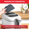 A hand is shown inserting a filter into a white air fryer on a kitchen counter. Produktbild-Vorschau