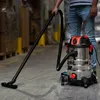A person is using a wet/dry vacuum cleaner in a warehouse. Náhľad obrázku produktu