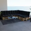 A sectional sofa made of pallets with black cushions on a balcony overlooking the ocean. Anteprima dell’immagine prodotto