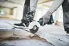 A person is using a cordless angle grinder to cut a metal rod on a construction site. Produktbild-Vorschau