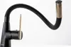 A black kitchen faucet with a flexible gooseneck spout and a gold accent on the handle and spout tip, set against a white background. Produktbild-Vorschau