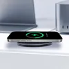 A smartphone is wirelessly charging on a charging pad, with a laptop and a silver device in the background. Produktbild-Vorschau