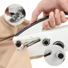 A hand is holding a portable sewing machine and operating it on a piece of fabric. Produktbild-Vorschau