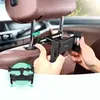 A person is installing a black car headrest mount for a smartphone or tablet in a car. Náhled obrázku produktu