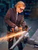 A person is using an angle grinder in a workshop. Produktbild-Vorschau