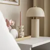 A bedside table with a lamp, candle, vase with flowers, and a tray with a perfume bottle. Produktbild-Vorschau