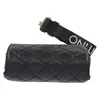 A black quilted cylindrical handbag with a black strap with white lettering is shown against a white background. Anteprima dell’immagine prodotto