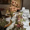 A dining table set for a festive occasion, with a Christmas tree in the background. Produktbild-Vorschau