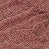 A close-up view of a textured fabric, likely a blanket or throw, with a woven pattern in burgundy and beige. Podgląd zdjęcia produktu