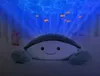 A baby sleeping in a crib with a crab-shaped projector casting an ocean scene with fish onto the ceiling. Náhled obrázku produktu