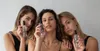 Three women are posing and holding bottles of Byrokko Tanning Mist. Produktbild-Vorschau