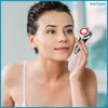A woman is holding a facial massage device to her cheek. Náhľad obrázku produktu
