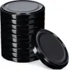 A stack of black metal jar lids with one lid placed in front of the stack. Podgląd zdjęcia produktu