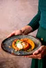 A person holding a plate with a stuffed pumpkin. Náhľad obrázku produktu