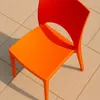 An orange chair is placed on a tiled outdoor surface. Voir les images du produit