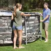A man and a woman are assembling an oval above-ground pool in a grassy backyard. Náhled obrázku produktu