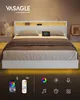 A modern white bed with a headboard featuring integrated lighting and charging capabilities, set against a warm, neutral background. Náhled obrázku produktu