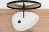 A white oval basin sink with black fixtures is mounted above a wooden surface. Anteprima dell’immagine prodotto