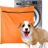 A washing machine, an orange laundry bag, and a corgi puppy are shown together. Produktbild-Vorschau
