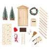 A collection of miniature Christmas-themed decorative items, including trees, a door, a wreath, a mailbox, a sled, a broom, and other accessories, arranged on a white background. Produktbild-Vorschau