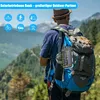A person wearing a backpack with a solar power bank attached, hiking in a mountainous area. Produktbild-Vorschau