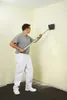 A man is using a wallpaper perforator tool on a wall in a room. Podgląd zdjęcia produktu