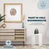 A white acrylic stool with a black handbag on top, placed next to a wooden dresser with a framed picture and decorative items. Produktbild-Vorschau