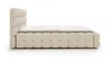 A side view of a cream-colored upholstered bed with a tufted headboard and frame, shown against a white background. Náhled obrázku produktu